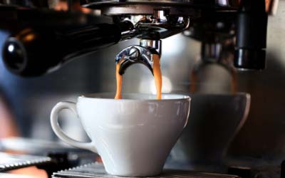 Billede af espressokaffe der brygges på maskine.